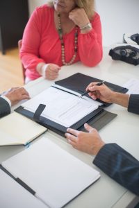 Senior couple and realtor discussing real estate contract at home office.